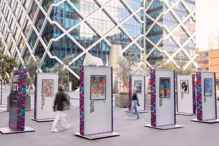 two people walking between outdoor art